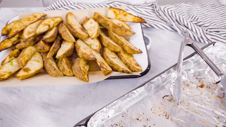 Step by step. Preparing russet potatoes in wedges with olive oil and spices to bake in the oven.