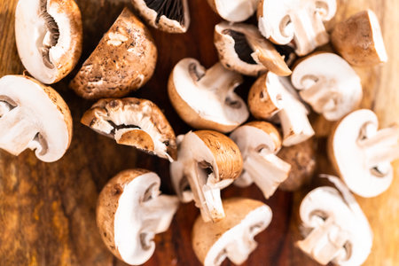 Cutting organic bella mushrooms on a wood cutting board.の写真素材
