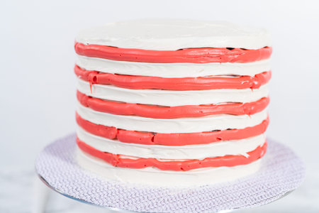 Decorating chocolate cake with white, red, and blue buttercream frosting for July 4th celebration.