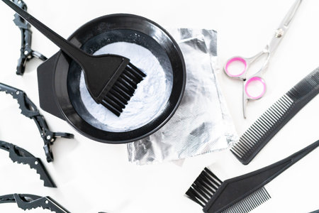 Hair color dye powder in a black plastic mixing bowl on a white background.の写真素材