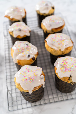 Glazing mini Easter bread kulich with a white lemon glaze.