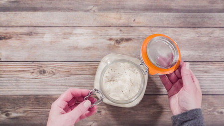 Flat lay. Baking homemade sourdough wheat bread in cast iron dutch oven.の写真素材