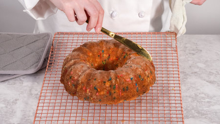Step by step. Removing freshly baked funfettti bundt cake from the bundt cake pan.
