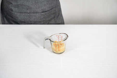 Mashed overripe banana in a glass measuring cup.の写真素材