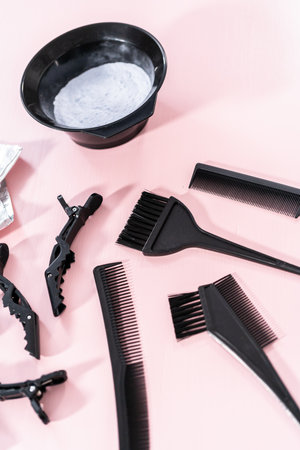 Hair color dye powder in a black plastic mixing bowl on a pink background.の写真素材