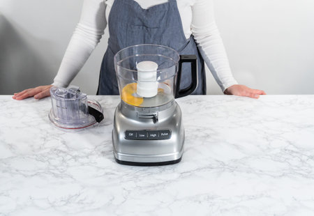 Mixing ingredients in kitchen blender to prepare homemade hollandaise sauce.