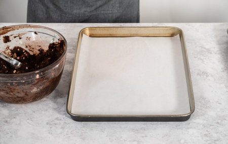 Scooping chocolate cookie dough with dough scoop to bake chocolate cookies with peppermint chips.の写真素材