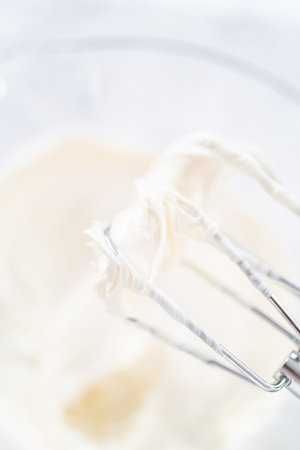 Preparing vanilla buttercream frosting for decorating funfettti bundt cake.の写真素材