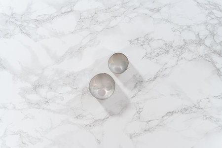 Flat lay. Lemon wedge cookies with lemon glaze. Metal round cookie cutters on a marble kitchen counter.の写真素材