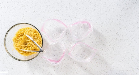 Flat lay. Packaging homemade frozen shrimp scampi meal prep into plastic resealable bags.
