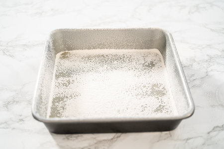 Greasing metal square baking pan to bake sweets.の写真素材