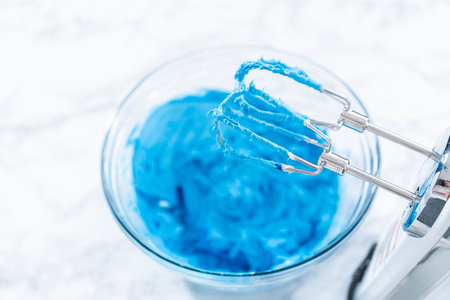 Mixing in food coloring into the store-bought vanilla buttercream frosting.の写真素材