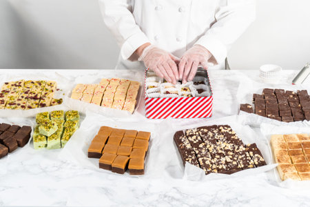 Packaging a homemade variety of fudge for Christmas food gifts into tin boxes.