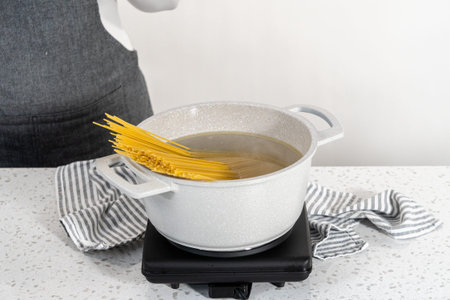 Boiling linguine pasta in a large cooking pot.