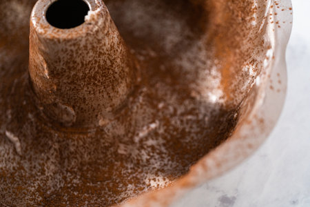 Greasing metal bundt cake pan to red velvet bundt cake with cream cheese glaze.の写真素材