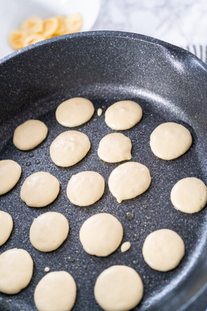 Frying mini pancake cereal in a nonstick frying pan.