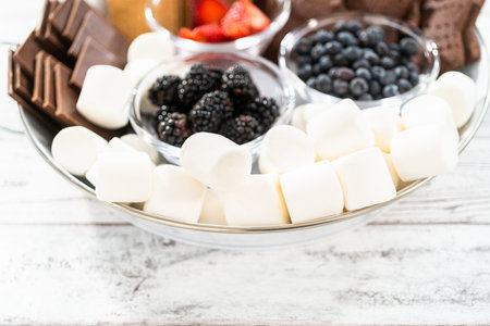Arranging fruit smores charcuterie board on a white tray.の写真素材