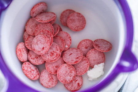Melting color chocolate melts in candy melting pot to prepare chocolate dipped pretzel rods for the...