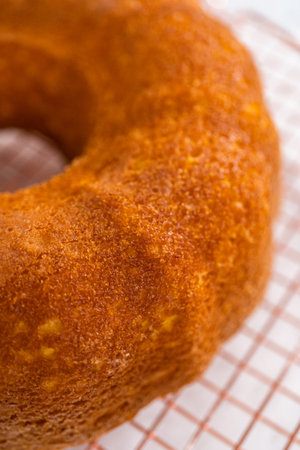 Cooling freshly baked simple vanilla bundt cake on a kitchen counter.