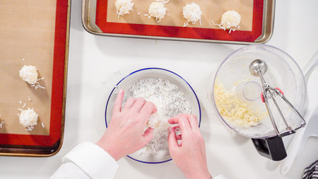 Flat lay. Scooping cookie dough into the baking sheet to bake coconut cookies.の写真素材