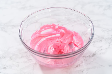Mixing pink food coloring into the meringue to bake Easter meringue cookies.の写真素材
