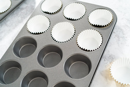 Lining cupcake pan with foil cupcake liners to bake smores cupcakes.の写真素材