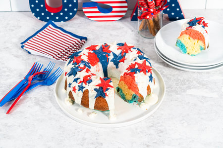 Slicing July 4th bundt cake covered with a vanilla glaze and decorated with chocolate stars.の写真素材