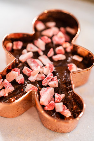 Filling cookie cutter with fudge mixture to prepare Christmas cookie-cutter peppermint fudge.の写真素材