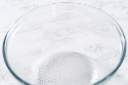 Rising dough in a glass mixing bowl to bake mini Easter bread kulich.の写真素材