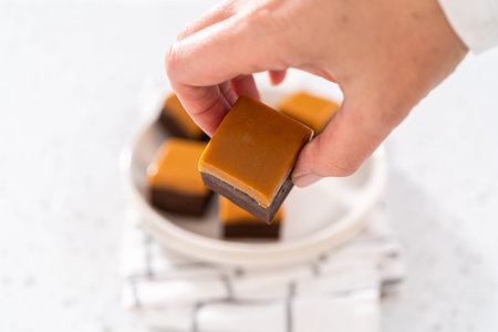 Homemade caramel fudge square pieces on a white plate.の写真素材