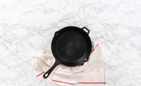 Flat lay. Heating cast iron skillet over the stove to prepare spinach and ham frittata.の写真素材