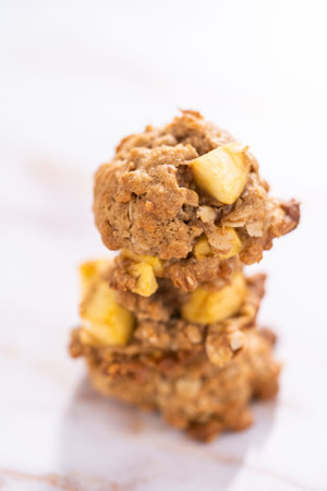 Stacked freshly baked apple oatmeal with apple chunks cookies.の写真素材