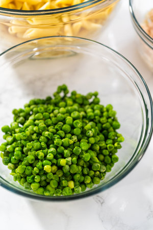 Measured ingredients in glass mixing bowls to make macaroni salad with chicken.の写真素材