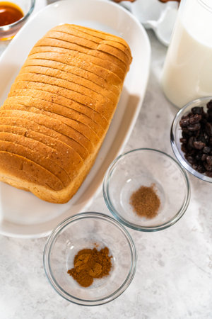 Measured ingredients in glass mixing bowls to bake bread pudding.