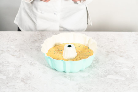 Cake batter in a bundt cake pan to bake funfettti bundt cake.の写真素材