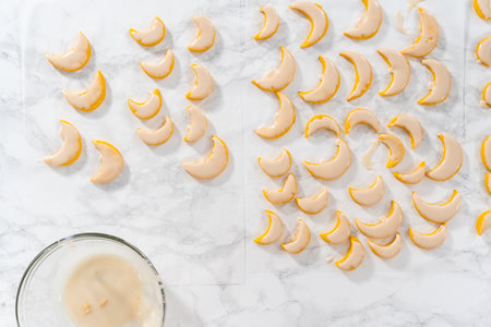 Flat lay. Lemon wedge cookies with lemon glaze. Dipping lemon cookies into a lemon glaze.の写真素材