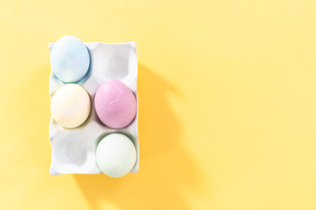 Colored hard-boiled eggs on a yellow background.