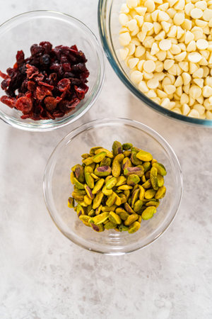 Measured ingredients in glass mixing bowls to prepare cranberry pistachio fudge.の写真素材