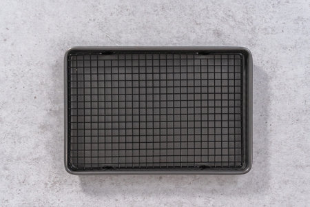 Flat lay. Empty baking sheet with wire rack on a gray background.
