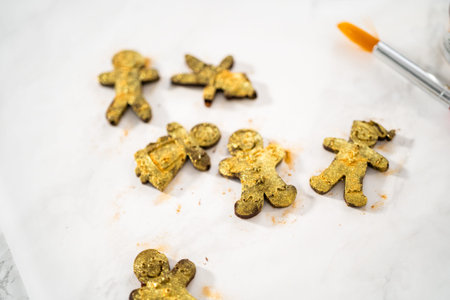 Dusting chocolate ginger man with food golden dust for cake toppers.の写真素材