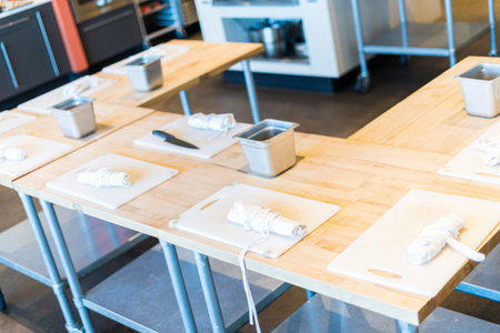 Tables prepared with white cutting boards and aprons for cooking class.