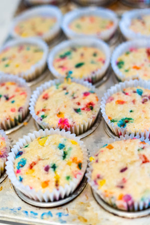 Funfetti cupcakes are cooling in a cupcake pan.