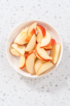 Thinly sliced red apples on a white plate.の写真素材