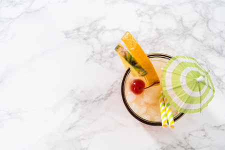 Flat lay. Freshly made Sunset cocktail garnished with a slice of fresh orange and pineapple.の写真素材