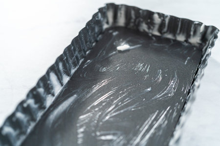 Close up view. Greasing French baking tart dish with vegetable shortening.の写真素材