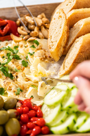 A large vegetarian party butter board with fresh and pickled vegetables and sliced french baguette for a party.の写真素材