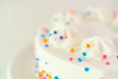 White little birthday cake with funfetti sprinkles on a white cake plate.の写真素材