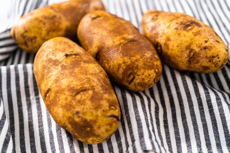 Pressure Cooker Baked Potatoes. Drying washed raw potatoes with a kitchen towel.の写真素材