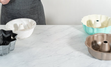 Different colors and shapes of bundt cake pans on the kitchen counter.の写真素材