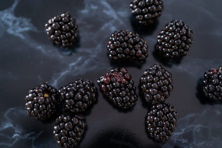 Fresh organic blackberries on ablack marble surface.